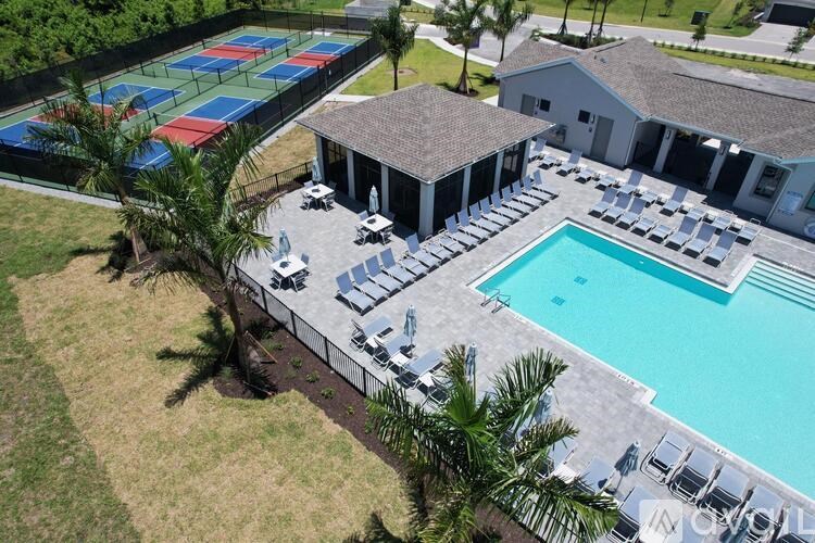 A pool with a tennis court and a pavilion.