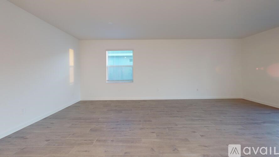 A room with wooden flooring and a window.