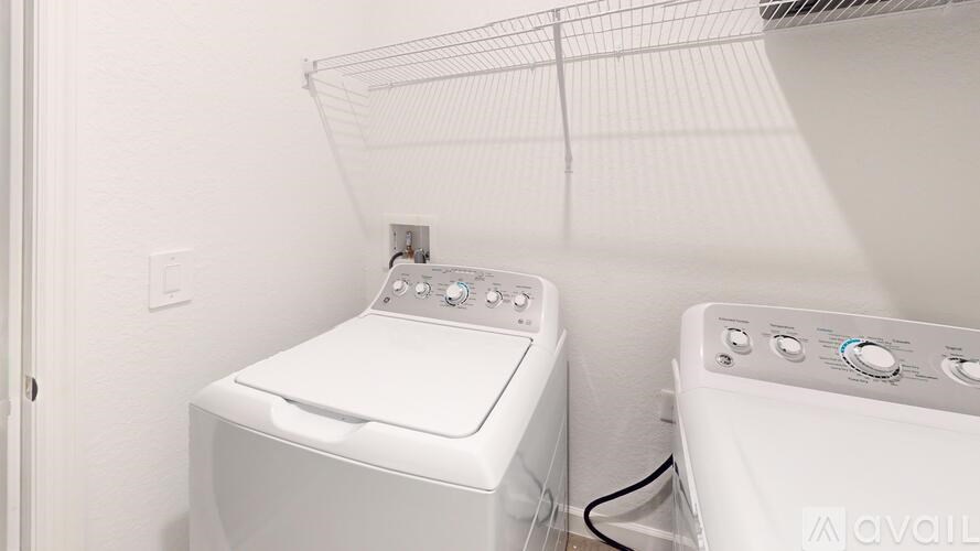Two front load washing machines in a small laundry room.