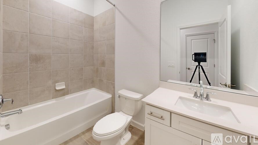 A bathroom with a white toilet, sink, and bathtub.