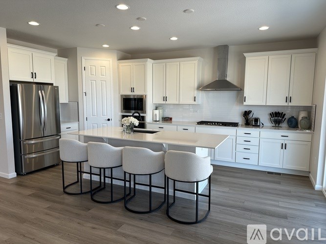 A modern kitchen with white cabinets and a central island.