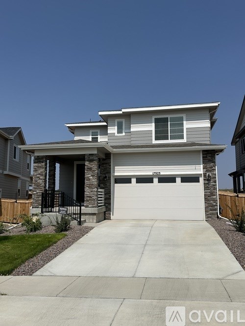 A two-story house with a garage and a driveway.
