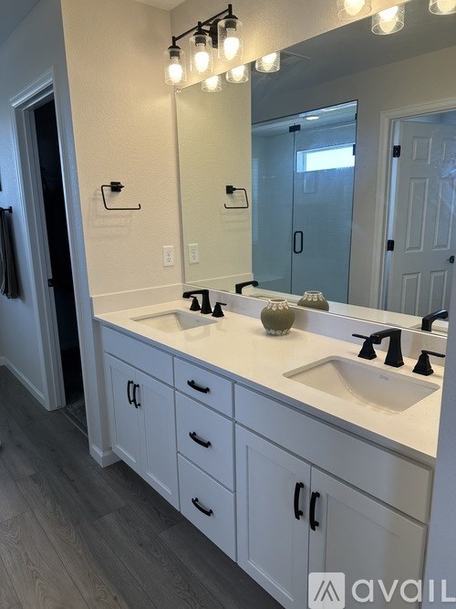 A bathroom with a vanity, sink, and mirror.
