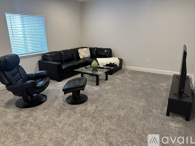 A living room with a black couch, chair, and coffee table.