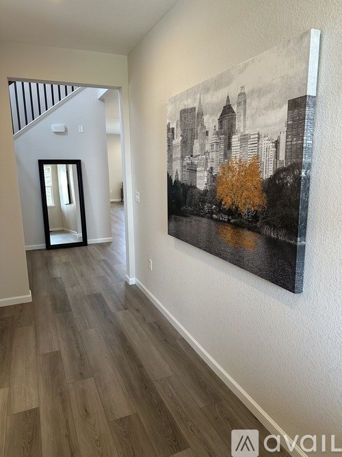 A hallway with a large painting of a cityscape on the wall.