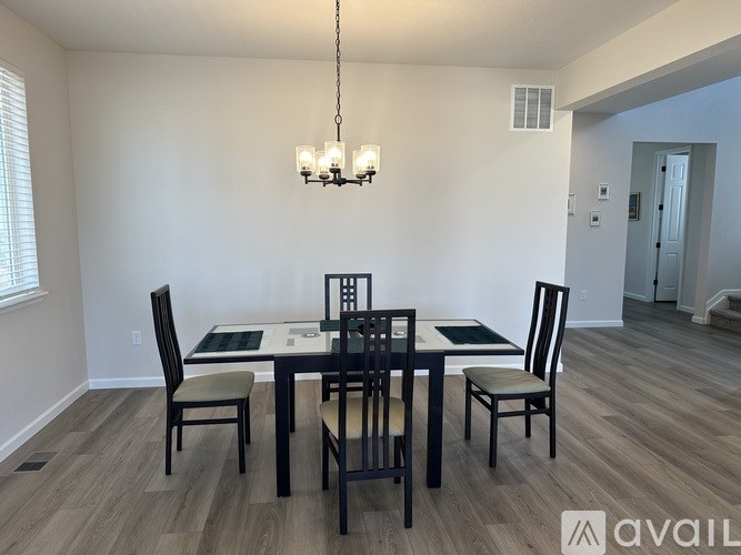 A dining room with a table and chairs.