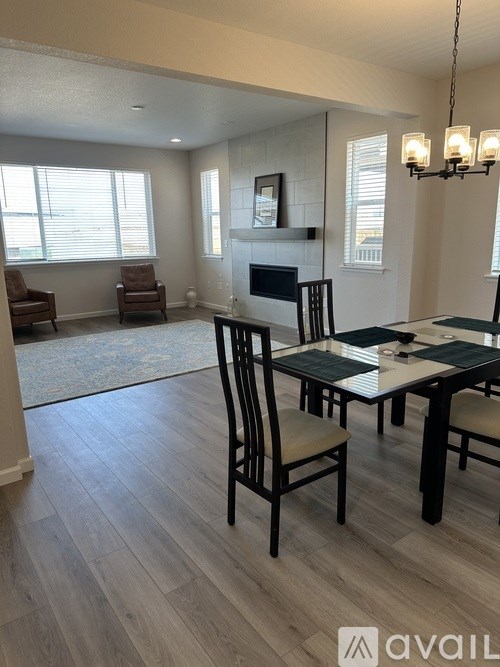 A dining room with a table set for four and a fireplace.