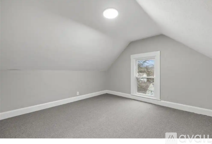 A room with a window showing a tree outside.