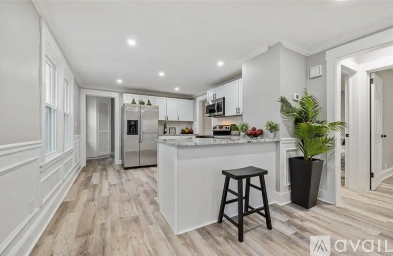 A kitchen with white cabinets and a wooden floor.