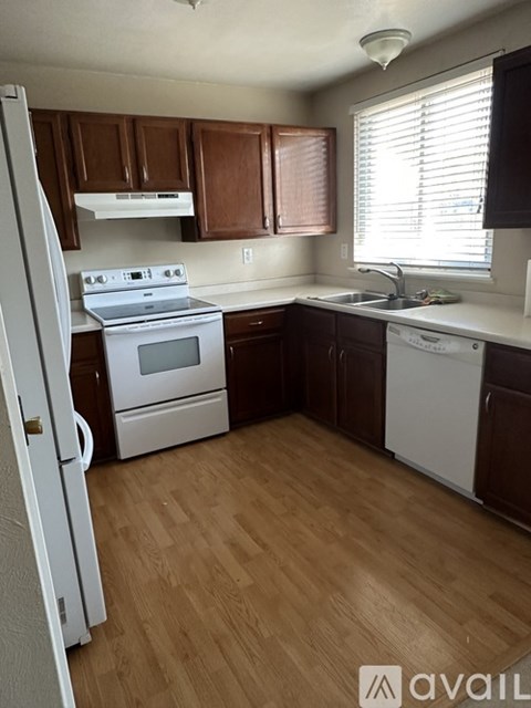 A kitchen with wooden cabinets and white appliances.