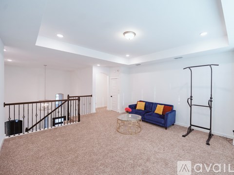 A living room with a blue couch and a black metal railing.