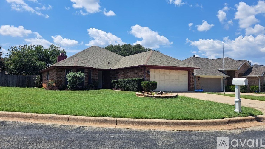 A house with a green lawn and a mailbox in front.