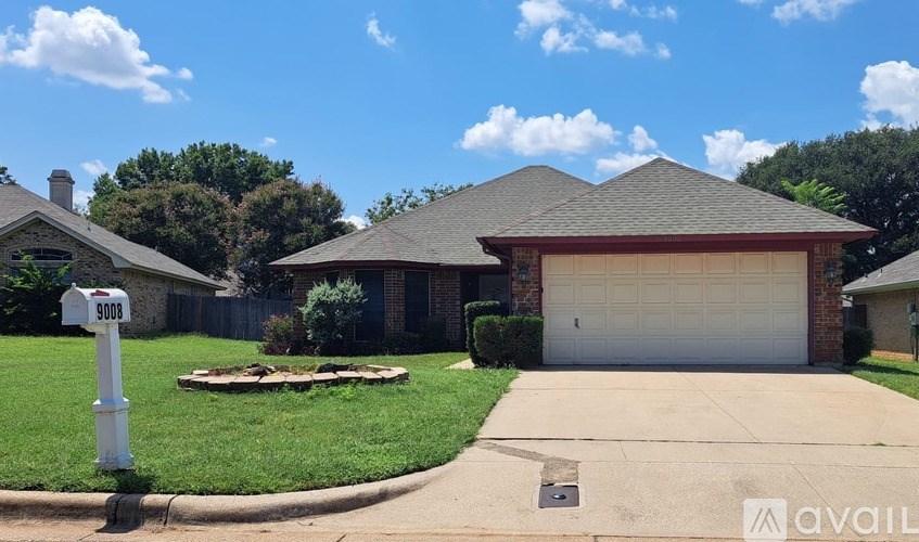 A house with a garage and a mailbox in front of it.