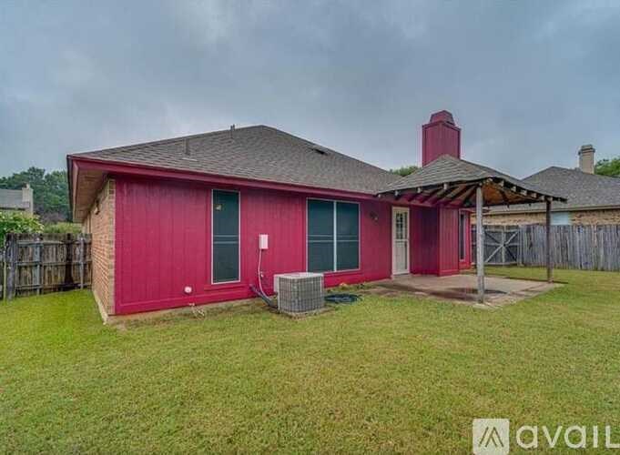 A red house with a black roof and a chimney.