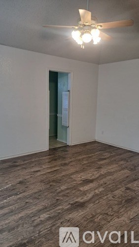 A room with a wooden floor and a ceiling fan.