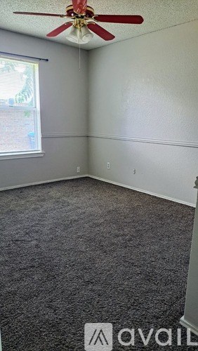 A room with a ceiling fan and a window.