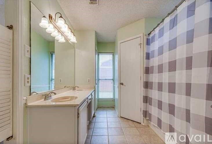A bathroom with a checkered shower curtain and a white sink.