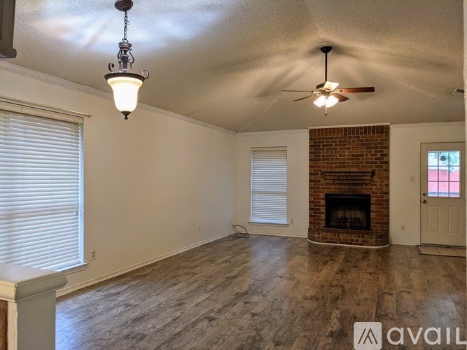 A room with a fireplace and a ceiling fan.