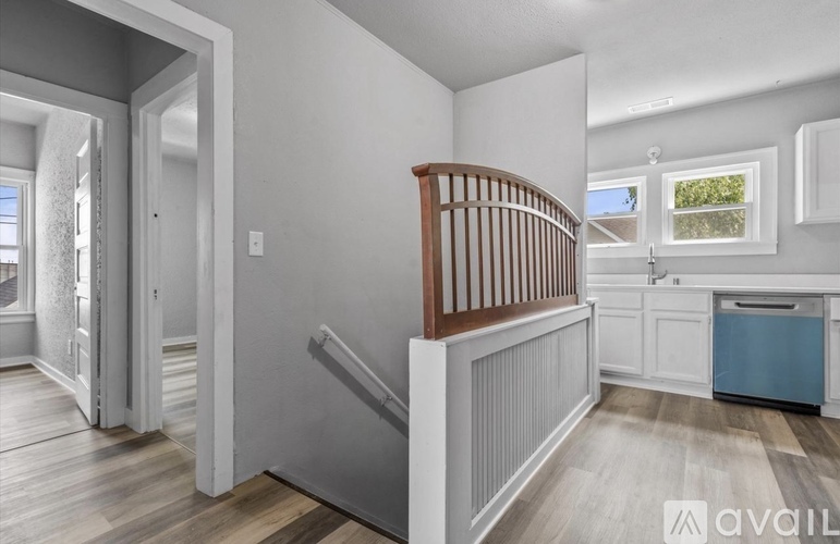 A well-lit, spacious room with a staircase and a window.