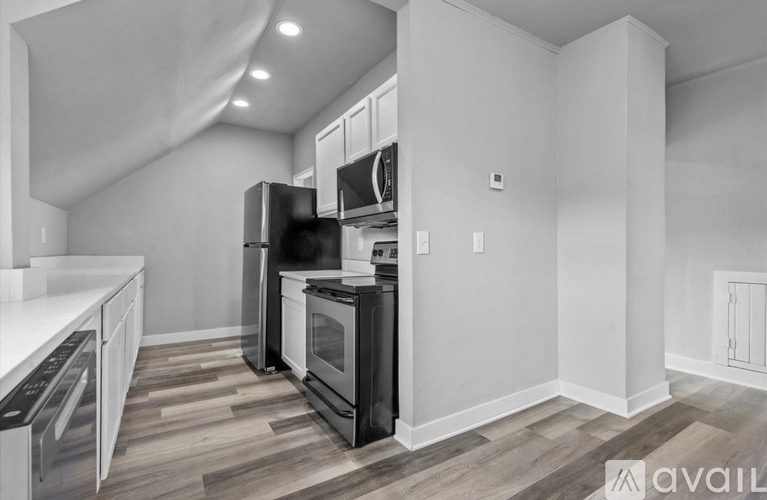 A kitchen with a black stove top oven and white cabinets.
