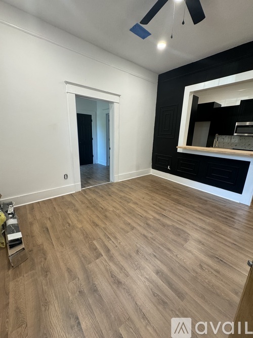 A room with wooden flooring and a ceiling fan.