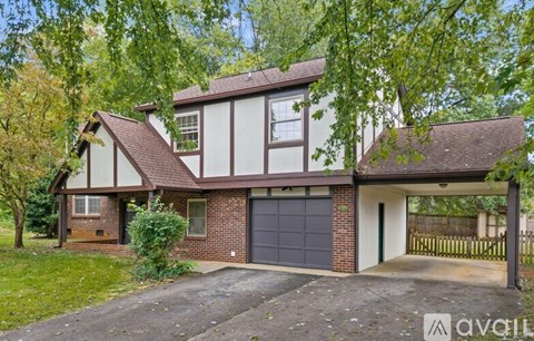 A house with a garage is surrounded by greenery.
