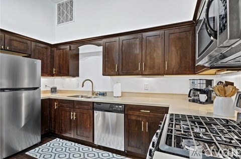 A kitchen with a stove top oven and a refrigerator.