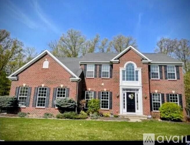 A brick house with a black front door and white trim.
