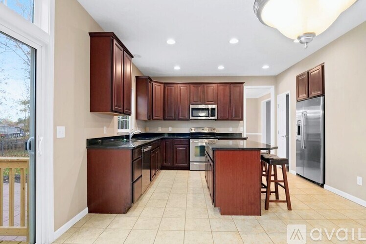 A kitchen with brown cabinets and a black countertop.