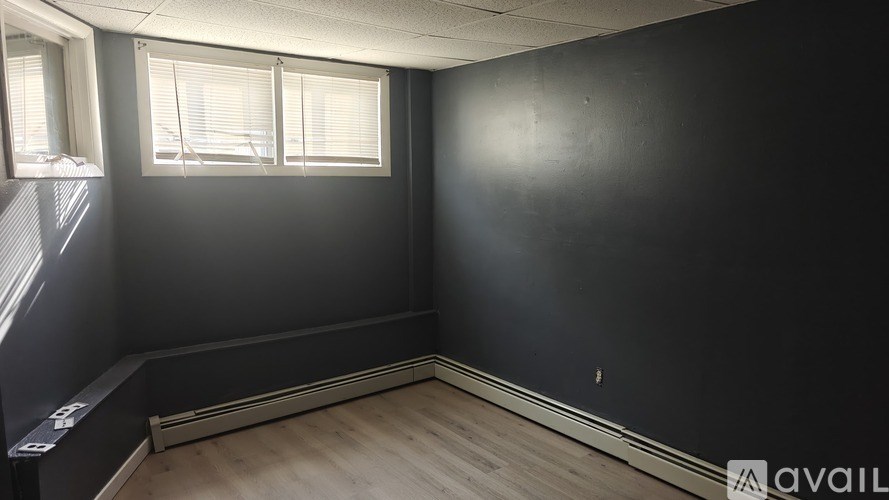 A room with a window and wooden flooring is available for rent.