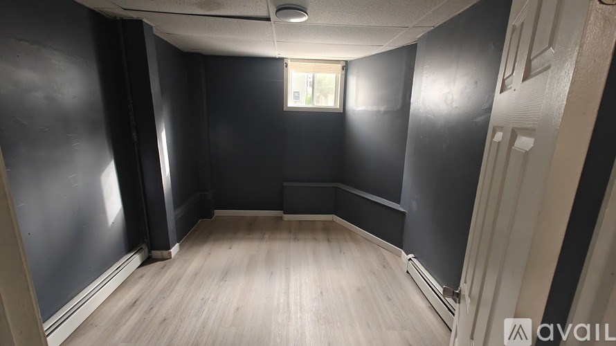 A room with wooden flooring and a window.