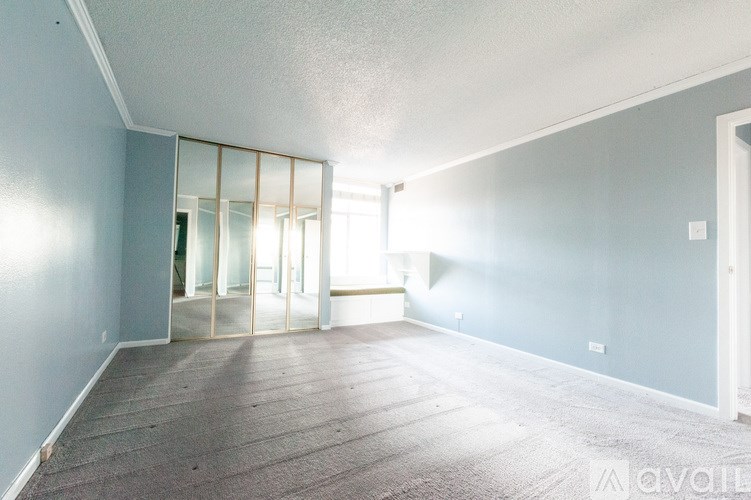 A room with a carpeted floor and a mirror on the wall.