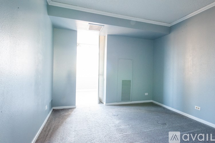 A room with a carpeted floor and a doorway leading to another room.