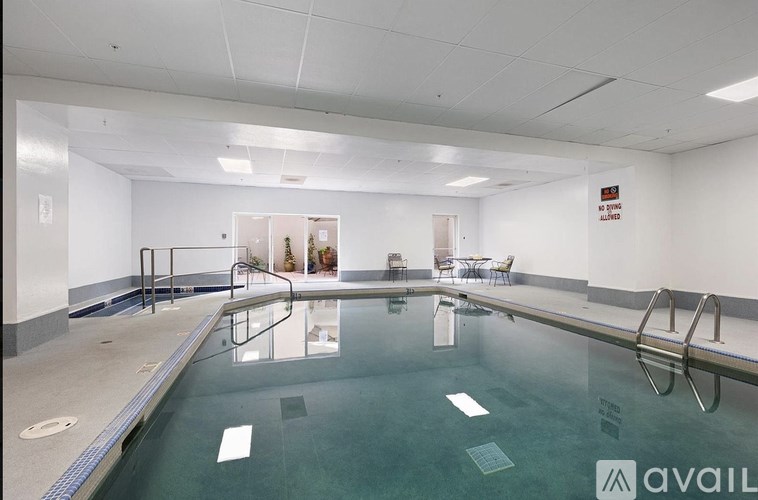 A large indoor swimming pool with a glass barrier and a sign on the wall.