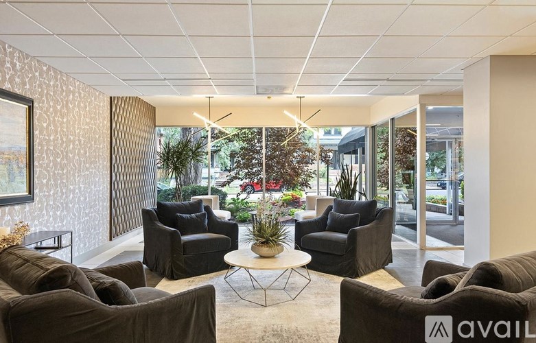 A waiting area with black chairs and a table in the middle.