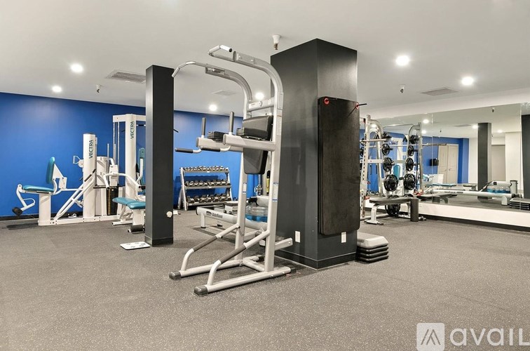 A gym with blue walls and various exercise equipment.