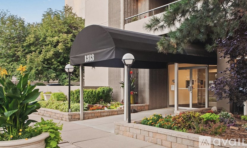 A building entrance with a black awning and a glass door.