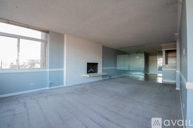 A spacious living room with a flat screen TV and large windows.