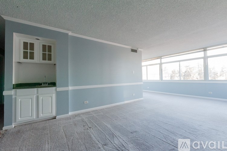 A room with a small kitchenette and a large window.