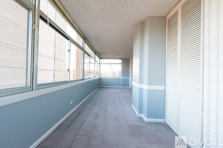 A long hallway with a carpeted floor and white walls.
