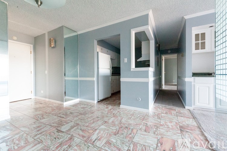 A spacious, empty room with marble flooring and a mix of grey and white walls.