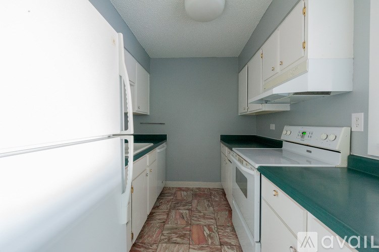 A kitchen with white appliances and green countertops.
