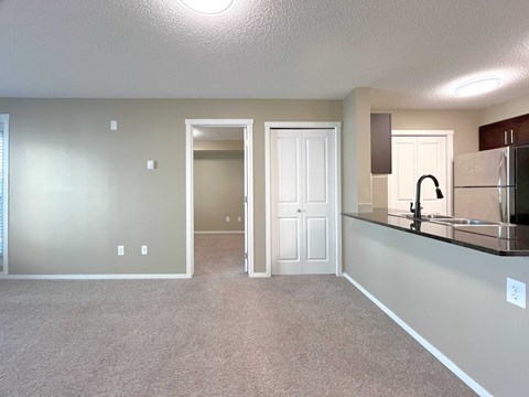A kitchen area with a sink and a refrigerator.