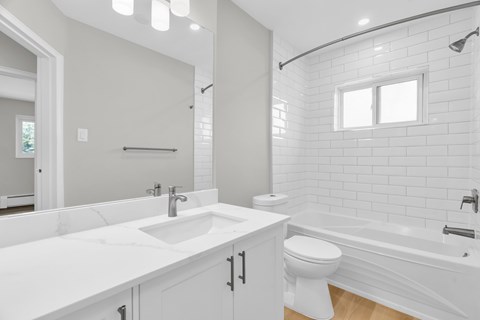 A white bathroom with a sink, toilet, and bathtub.