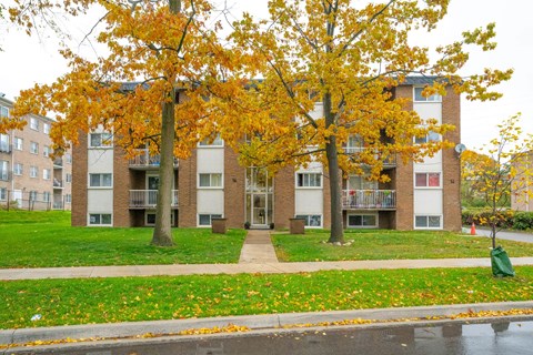 Apartment building with trees in front of it.