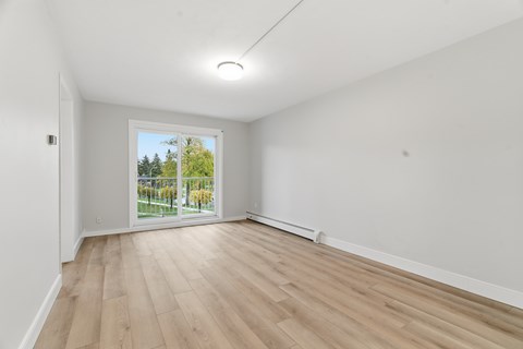 A room with a sliding glass door leading to a garden.