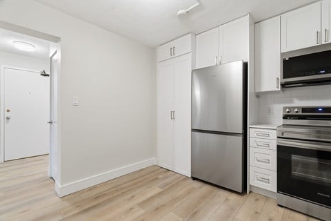A kitchen with a stainless steel refrigerator and oven.