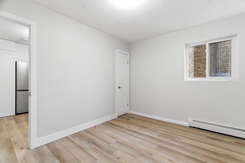 A room with a window and a wooden floor.