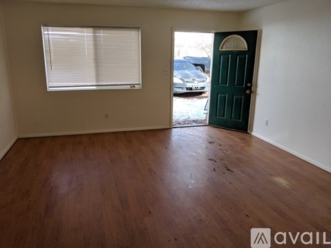 A room with wooden floors and a green door.