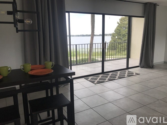 A dining area with a table set for two and a view of the outside.